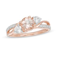 Make a contemporary statement of style with this entrancing gemstone ring. Fashioned in precious 10K rose gold, this three-stone look showcases a 6.0mm soft-pink morganite flanked by 3.5mm lab-created shimmering white sapphires - all set at a slant between bypassing polished ribbons. A curved row of diamond accents and beaded detailing completes the split-shank design. Buffed to a brilliant luster, this ring is perfect for everyday wear. Rose Gold Three Stone Jewelry, Rose Gold Three Stone Ring, Fine Rose Gold Three Stone Jewelry, Rose Gold Three Stone Fine Jewelry, Fine Jewelry In Rose Gold With Three Stones, White Diamond Ring, Bypass Ring, Pink Morganite, Sapphire Stone