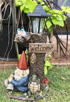 a welcome gnome statue sitting next to a lamp post