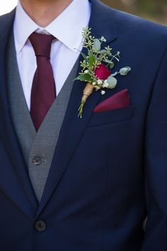 a man in a suit and tie with a boutonniere on his lapel