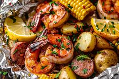 grilled shrimp, corn on the cob and potatoes in foil with garnish