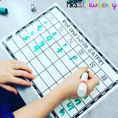 a person is playing a game with numbers and dices on the table next to some crayons