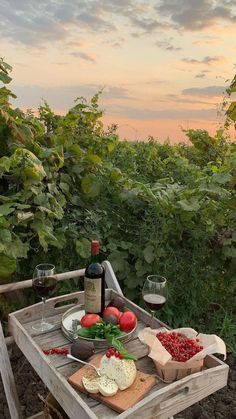 a wooden table topped with lots of food and wine