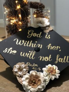 a graduation cap decorated with flowers and the words god is within her she will not fall