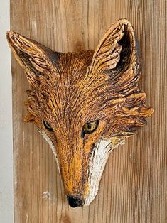 a wood carving of a fox's head on a wall