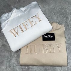 two white and gold shirts with the words wifey printed on them sitting next to each other