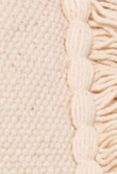 a close up view of the texture of a knitted blanket with white yarns