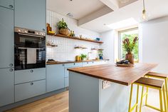 a kitchen with wooden counter tops and yellow stools