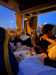 three girls sleeping in the back of a bus