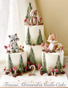 a cake decorated with animals and trees on it's tiered base is the number two