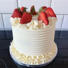 a cake with white frosting and strawberries on top