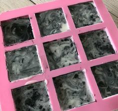 an ice tray with black and white marbled squares in it on top of a wooden table