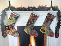 two stockings hanging over a fireplace with christmas decorations