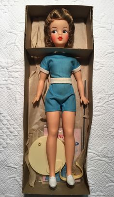 a doll in a cardboard box with clothes