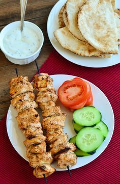 chicken skewers with cucumbers, tomatoes and pita bread