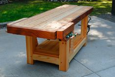 a wooden table sitting on top of a cement ground