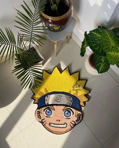 a rug with the character naruto on it next to a potted plant