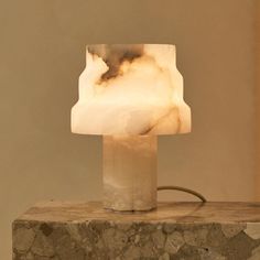 a lamp that is sitting on top of a rock slab in the middle of a room