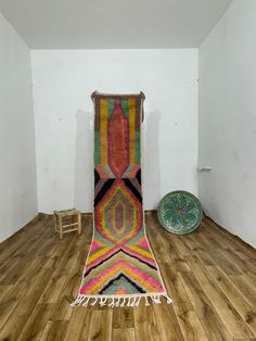 a room with wooden floors and a rug on the floor in front of a chair