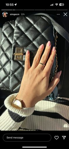 a woman's hand holding onto a purse on her cell phone, with the screen showing