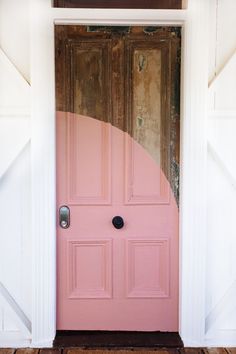 a pink door with two black knobs on it