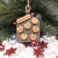 a wooden ornament hanging from a christmas tree filled with snowflakes and cookies