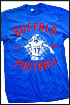 Buffalo Football Shirt. A homage shirt to our new franchise QB. A great shirt for some one who is Buffalo Football fan too! All of our shirts are printed on high quality, ultra soft, 100% cotton preshrunk American Apparel t-shirts. All printing is done in-house and is American made. Main design is on front. for more shirts visit our site: www.mybuffaloshirt.com Blue Graphic Print Sublimation Fan Gear, Blue Sublimation Design Shirt With Graphic Print For Fans, Blue Graphic Print Sublimation Design For Fan Gear, Fan Apparel T-shirt With Screen Print, Tri-blend T-shirt With Graphic Print For Fans, Football Season Sports Fan T-shirt With Screen Print, Football Season Fan Apparel T-shirt With Logo, Sports Fan T-shirt For Football Season With Screen Print, Throwback Graphic Print Tops For Football Season