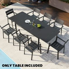 an outdoor dining table with six chairs next to a swimming pool