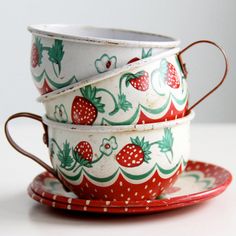 three cups and saucers stacked on top of each other with strawberries painted on them