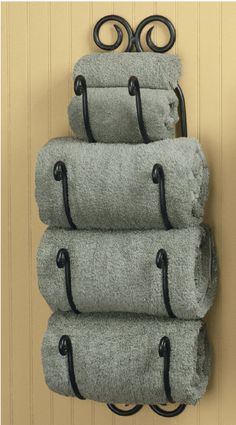 four towels are stacked on top of each other in front of a wall mounted towel rack