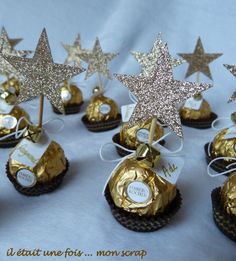 gold and white stars are on top of chocolate candies in small boxes with tags