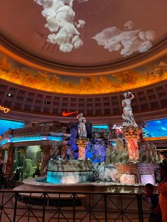 the ceiling is decorated with clouds and statues