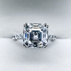 an emerald cut diamond ring with diamonds around it