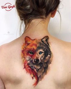 a woman with a tattoo on her back that has a wolf and fox design on it