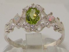 *This ring is made from 925 Sterling Silver with Natural Peridot & Opals.PLEASE MAKE SURE YOU STATE THE FINGER SIZE YOU REQUIRE WITH YOUR PAYMENT.This stunning ring has been set with a center 6x4mm (0.24" x 0.16") Peridot and two Fiery Opals on the shoulders measuring 2.25mm (0.09"). The contrast of the Vibrant Green Peridot with these colorful Pretty Opals set within this delicate yet strong setting, creates such an elegant look and feel, this ring is certainly a very special piece. The des Cute Engagement Rings, Trilogy Ring, Peridot Ring, Green Peridot, Cute Rings, Pretty Rings, Vibrant Green, Natural Earth, Delicate Rings