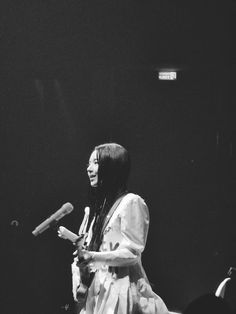 a black and white photo of a woman holding a microphone