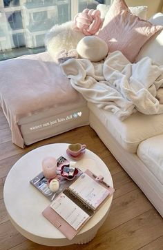 a white couch sitting next to a coffee table on top of a hard wood floor