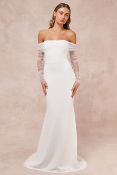 a woman in a white wedding dress with sheer sleeves and an off the shoulder top