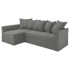 a gray couch with lots of pillows sitting on it's back end and one arm extended