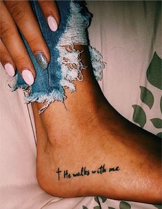 a woman's foot with the words, he walks with me tattooed on it