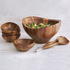 wooden bowls and spoons with salad in them