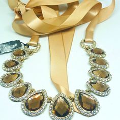 Cezanne Brown Glass Stone And Rhinestone Statement Necklace Has Original Tag Never Worn Beautiful Brown Faceted Teardrop Stones Clear Rhinestones Embellishments Gold Tone Metal With Gold Satin Tie Closure Statement Piece Gorgeous! Elegant Adjustable Teardrop Crystal Necklace, Elegant Teardrop Crystal Necklaces For Parties, Glamorous Crystal Necklace As A Gift, Gold Crystal Necklaces With Stones For Party, Elegant Adjustable Crystal Necklaces, Gold Party Crystal Necklace With Stones, Elegant Evening Rhinestone Necklace, Elegant Jeweled Crystal Necklaces For Formal Occasions, Elegant Gold Jeweled Crystal Necklace