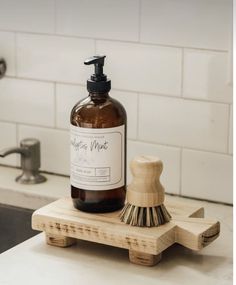 a soap dispenser sitting on top of a wooden stand next to a sink