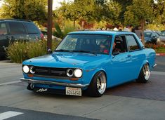 a blue car is parked on the side of the road