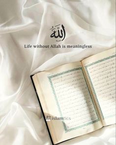 an open book sitting on top of a white sheet with arabic writing in the middle