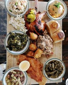 a wooden table topped with lots of different types of dishes and food on top of it