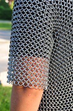 a close up of a person wearing a chain mail dress