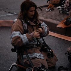 a firefighter sitting on the ground with her equipment