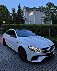 a white car parked in front of a house