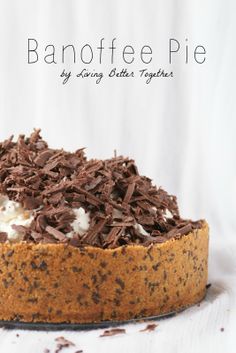 a chocolate cake topped with whipped cream and chocolate shavings on a white surface