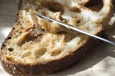 a piece of bread that has been sliced and is being held by a pair of scissors